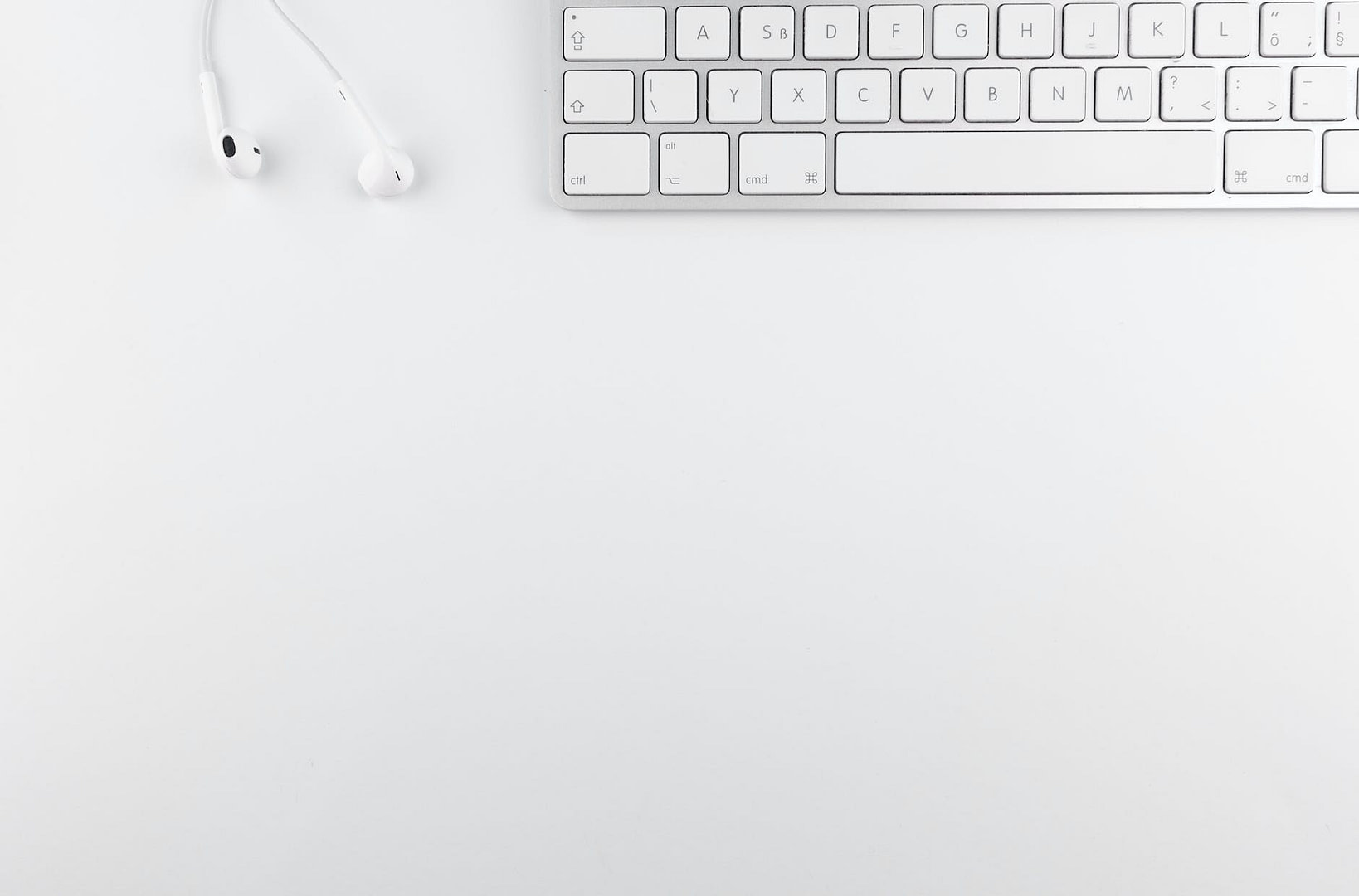 top view photo of keyboard near earphones